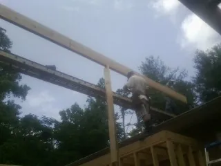 Carpenter setting a ridge beam over a new addition frame — Ice Dam Removal by Roofing Brothers in Delmont