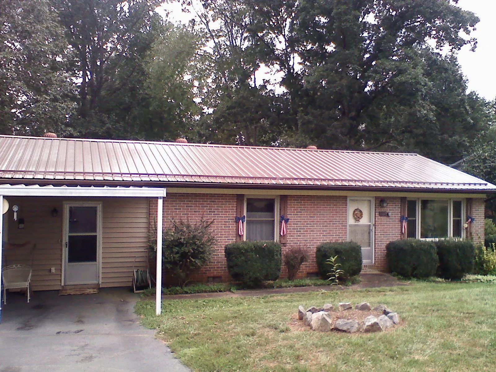 Bronze metal roof and carport on a brick ranch home — Roof Repair work by our crew in Delmont